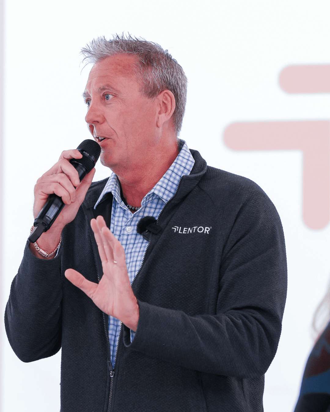 Ric Devore speaking into a microphone at a Lentor event